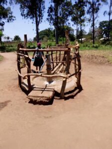 Borehore surrounded by wooden frames, with a woman approaching